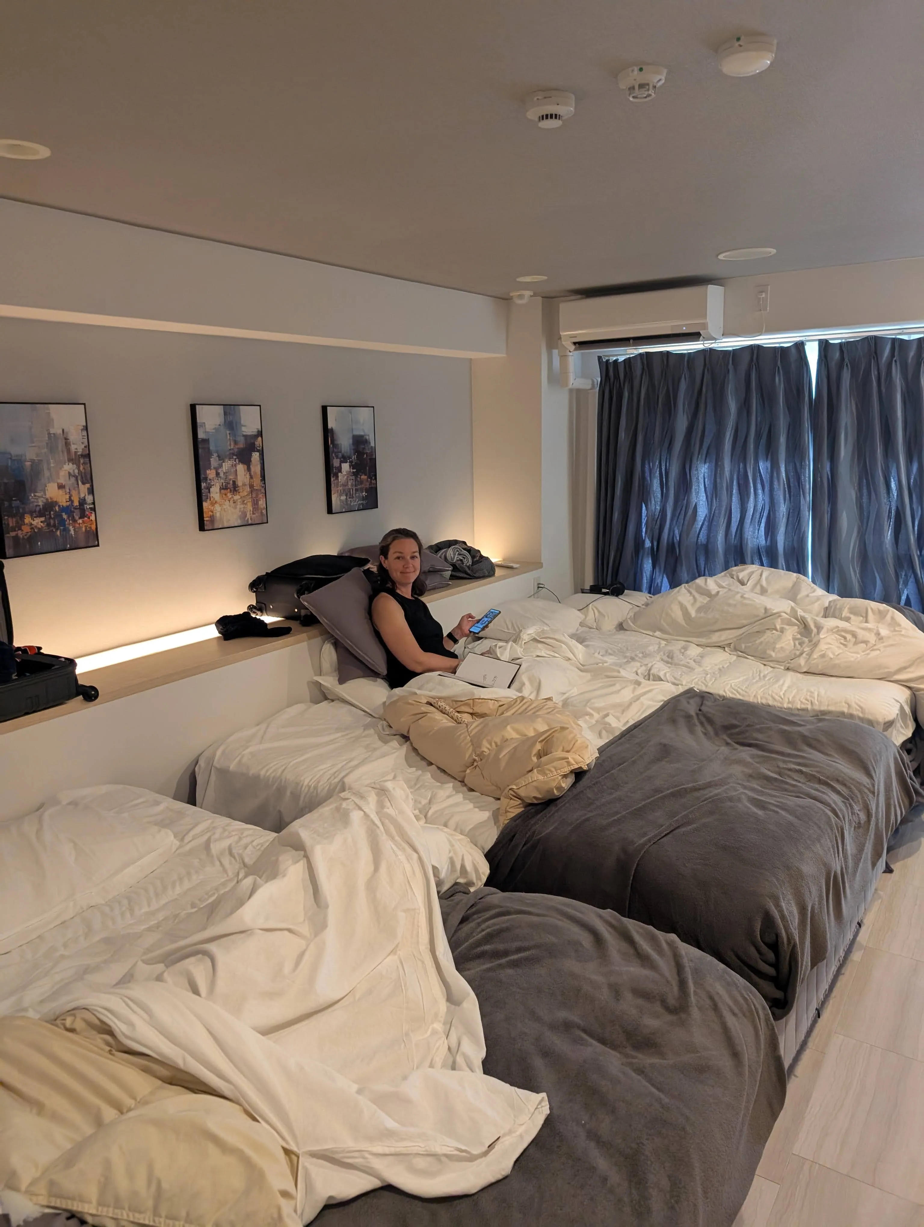 The bedroom of our apartment near Dotonbori in Osaka, with beds for the whole family and city artwork on the wall