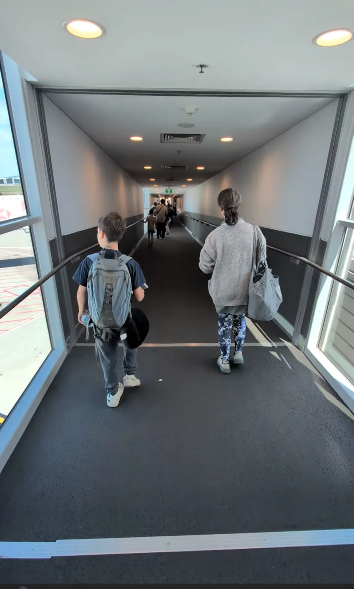 One of the boys and Lyndsie walking down the air bridge to board the flight to Japan