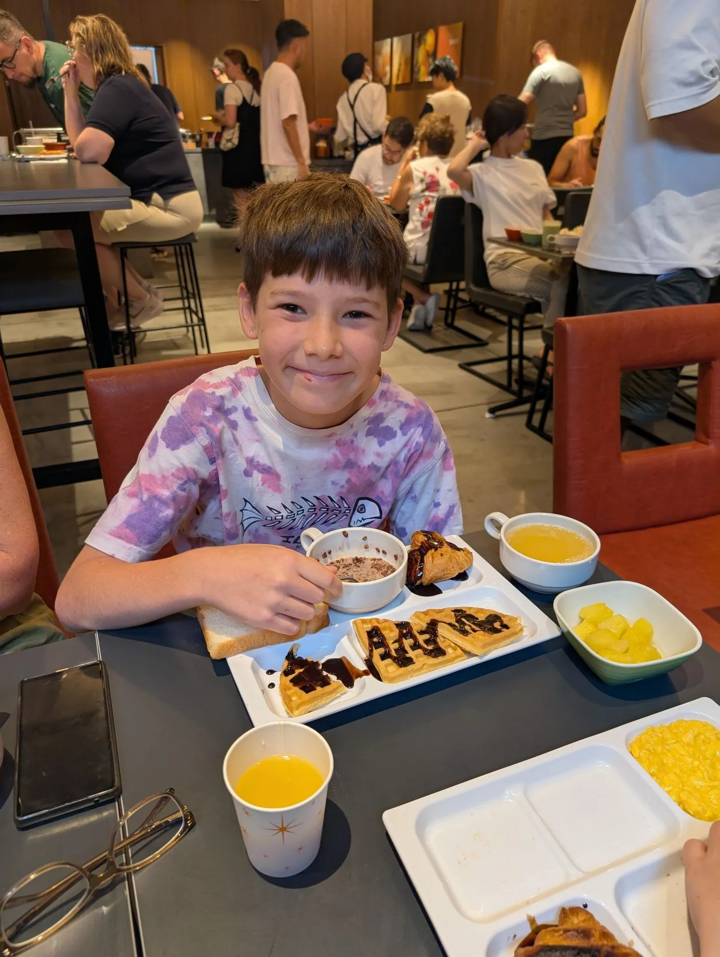 A child with a chocolate waffle at a hotel breakfast in Kyoto