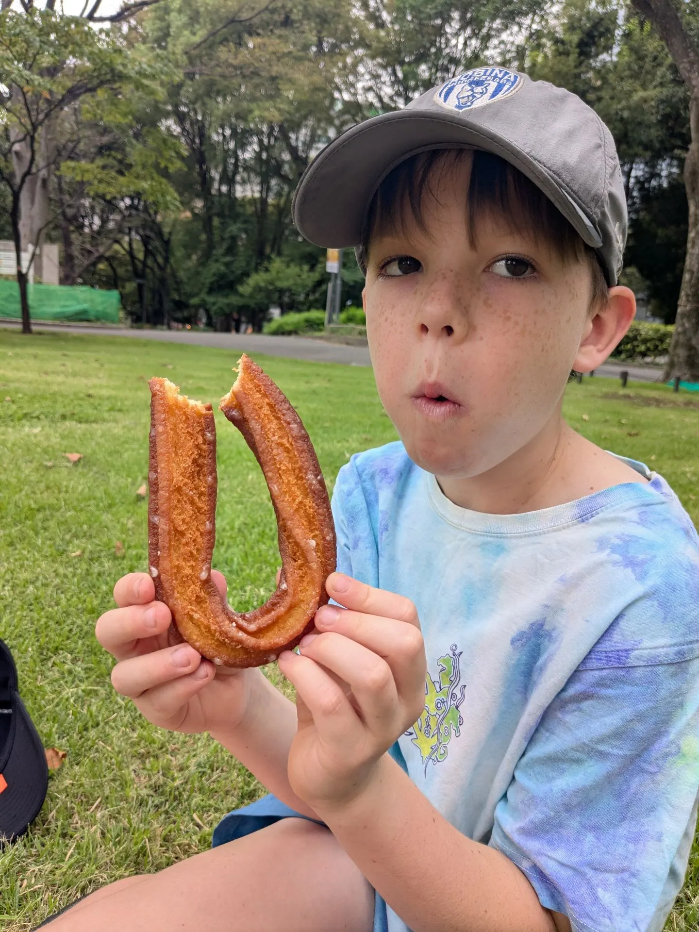 A child eating a churro in Shinjuku Gyoen park, Tokyo