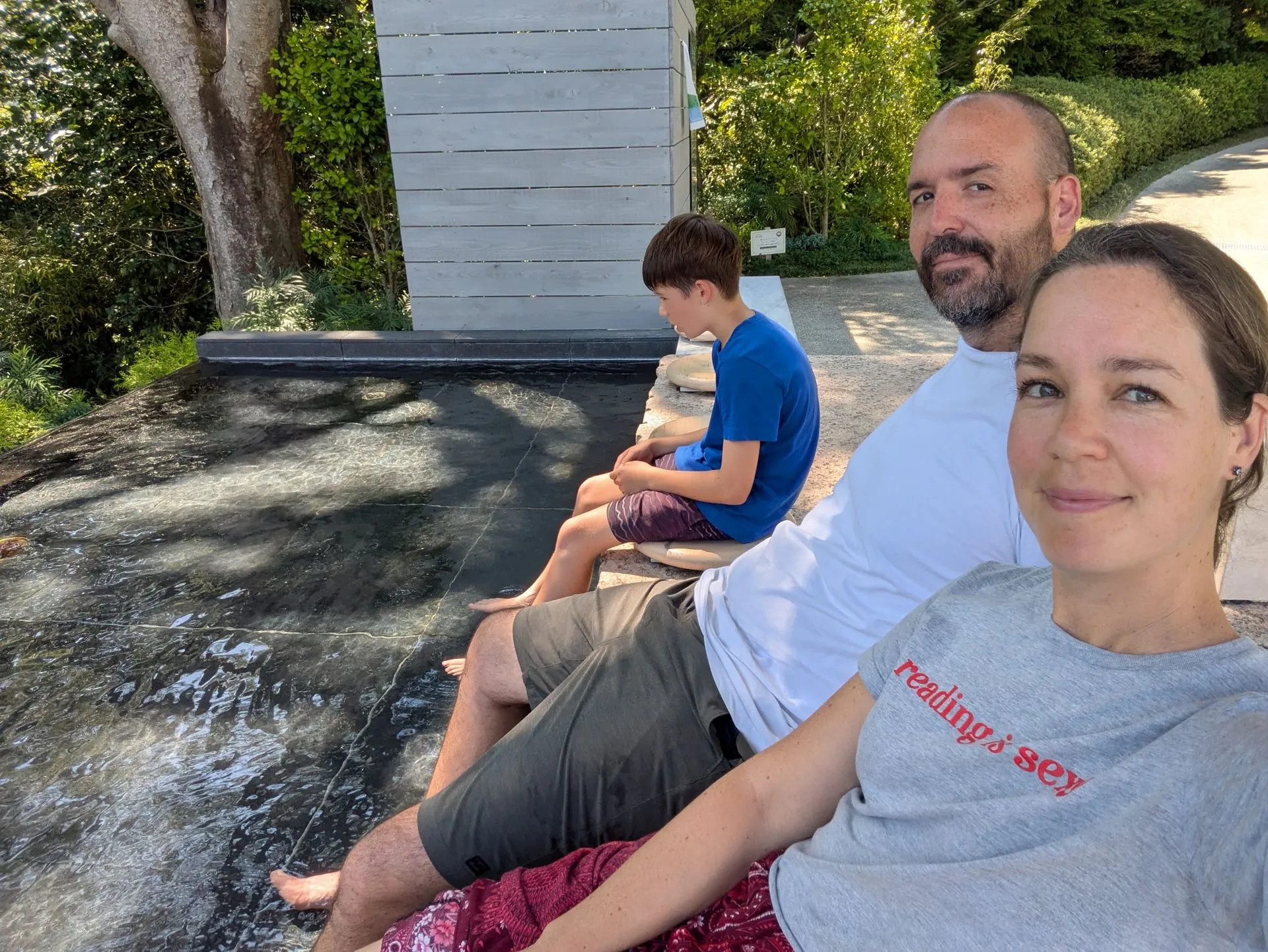 Family soaking feet in the natural hot spring foot bath at Hakone Open Air Museum