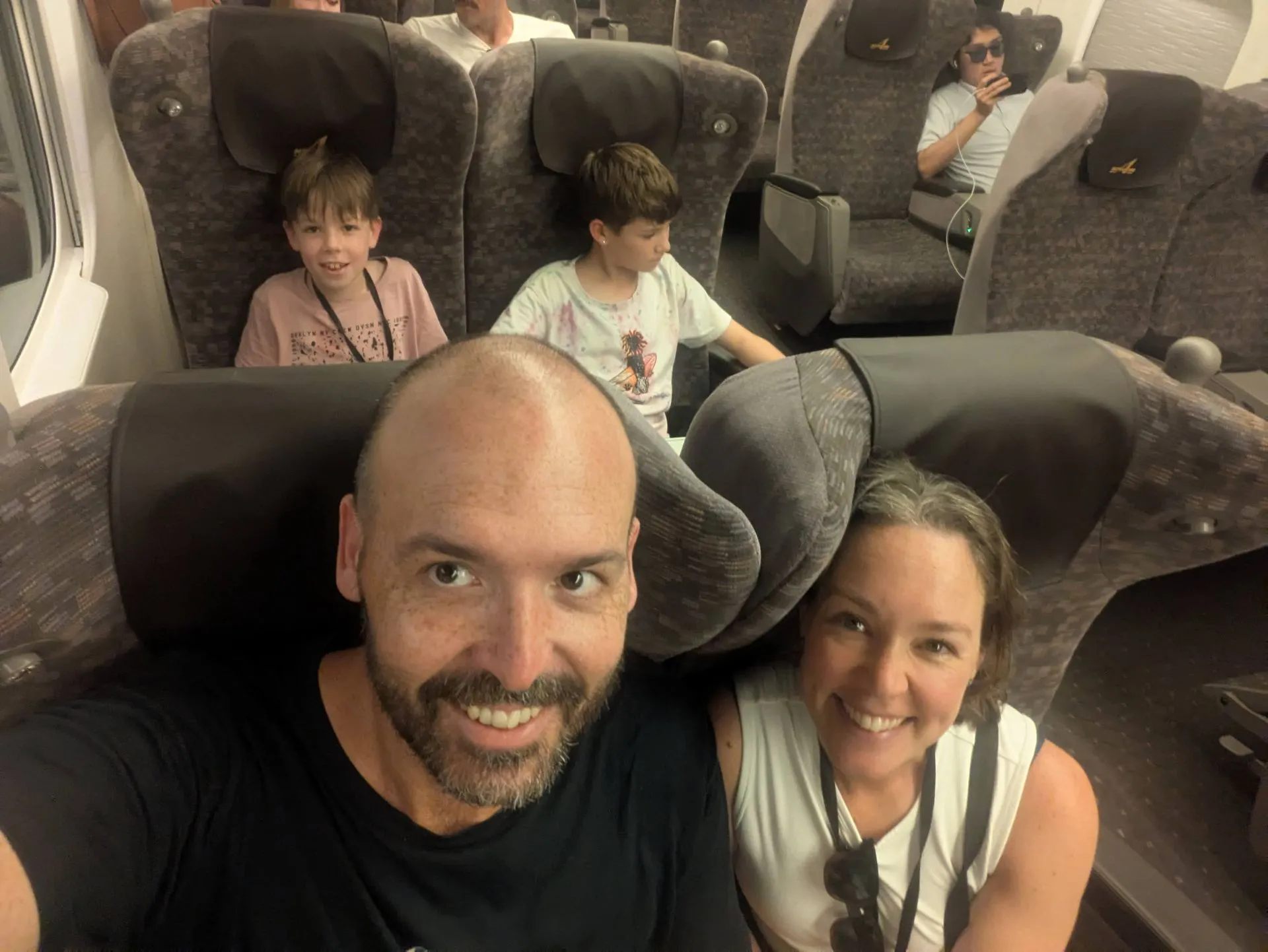 Family taking a selfie in their Shinkansen seats on the way to Hakone