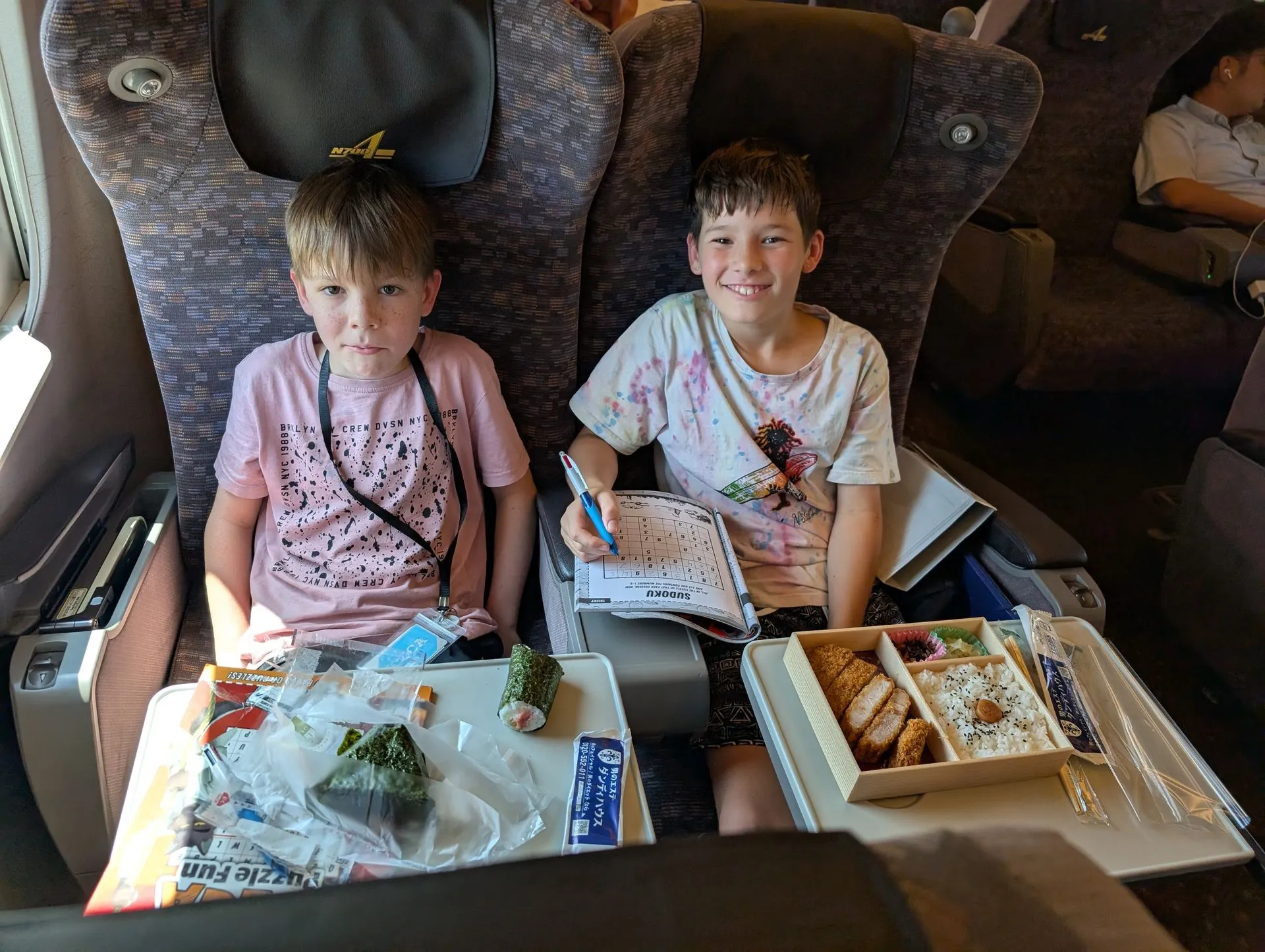Kids eating ekiben bento boxes on the Shinkansen to Hakone