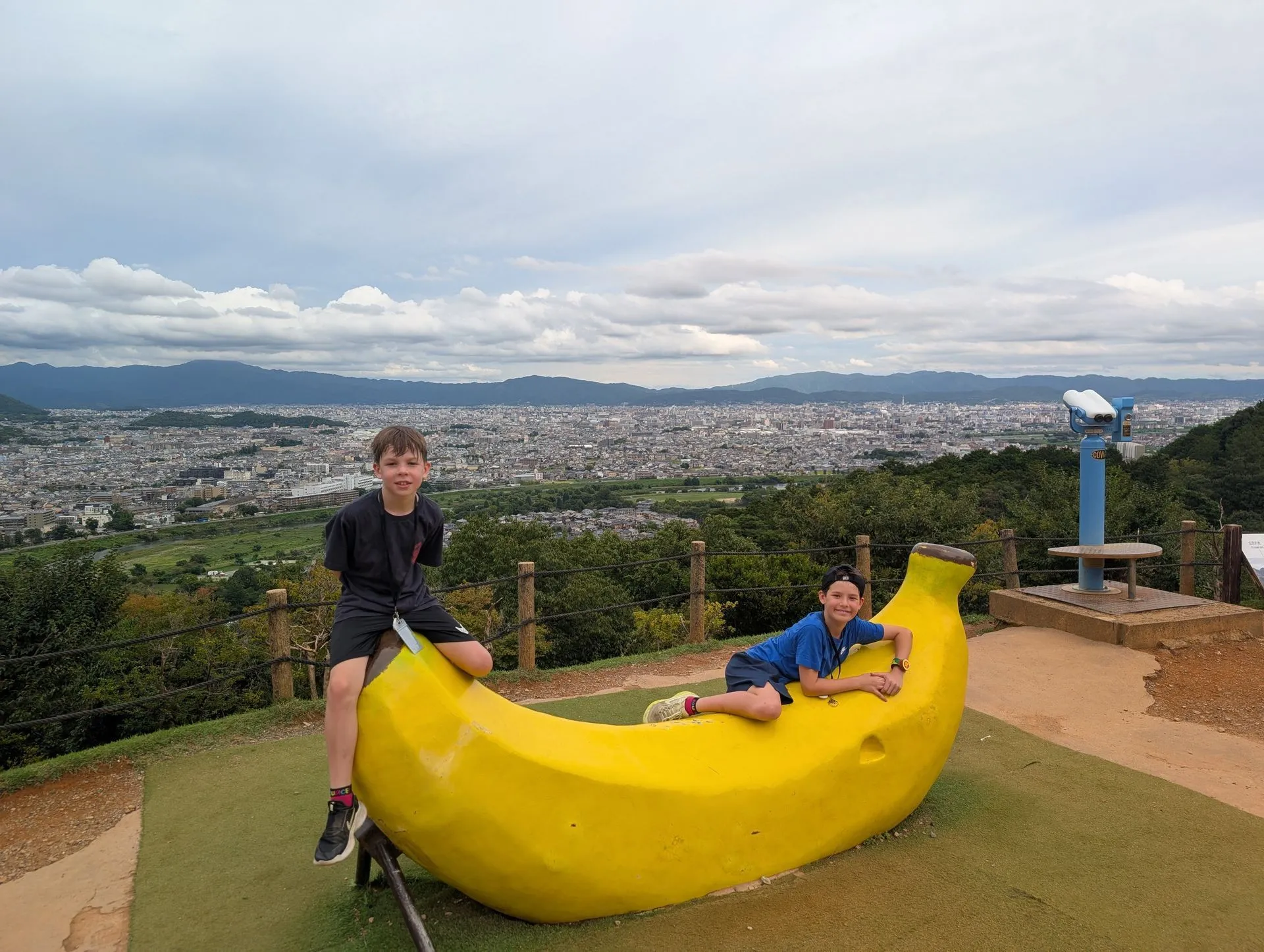 Giant banana sculpture at Arashiyama Monkey Park with Kyoto city view behind