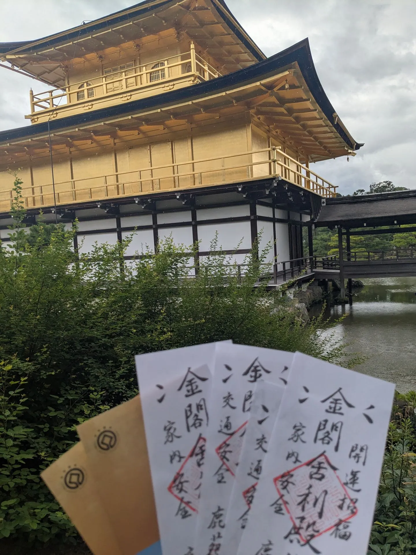 Paper entry tickets and omamori charms bought at Kinkakuji temple in Kyoto