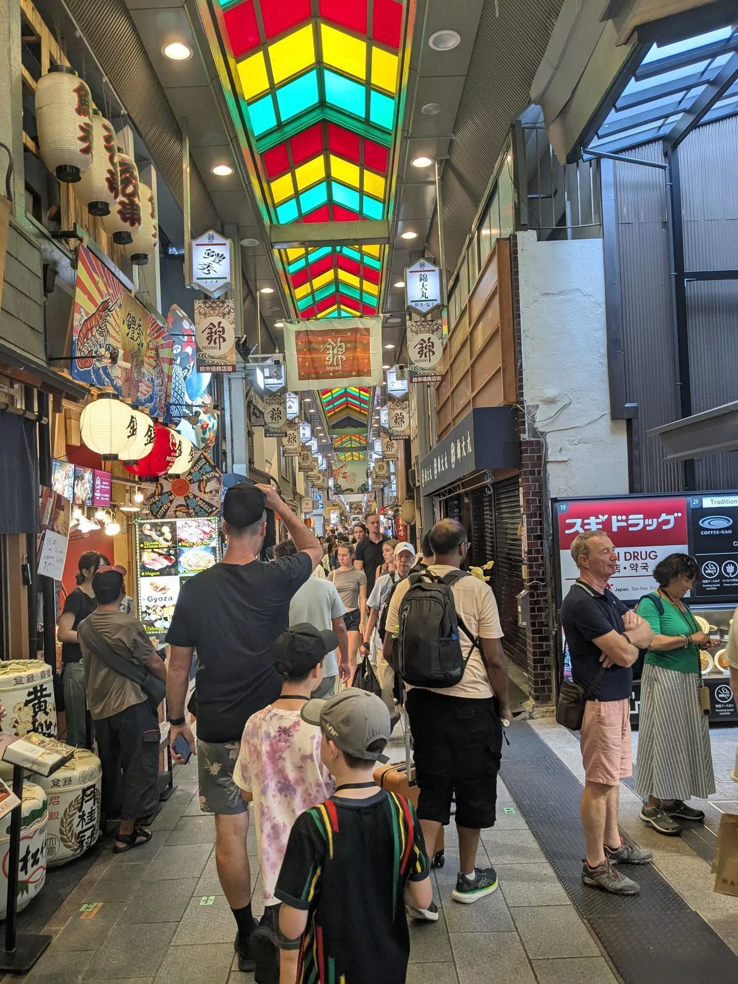 The covered arcade of Nishiki Market in Kyoto with food stalls on both sides