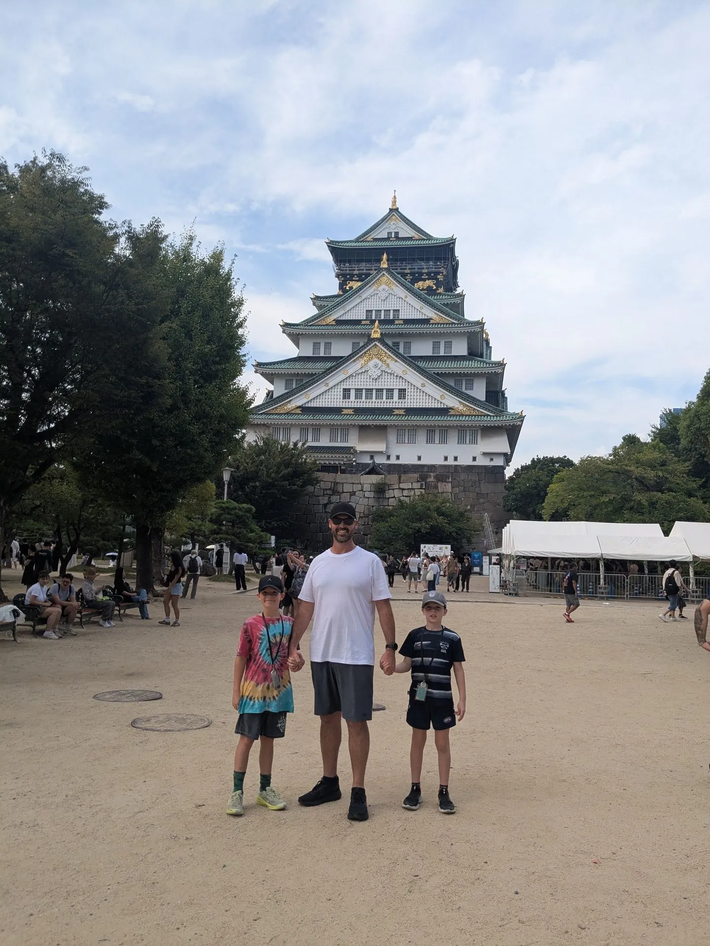 Family photo at Osaka Castle with the main keep visible behind them