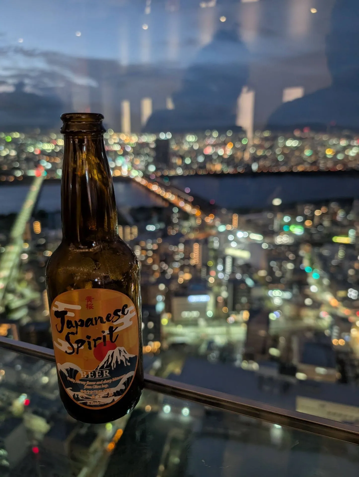 Japanese beer on the Umeda Sky Building rooftop at night with city lights behind