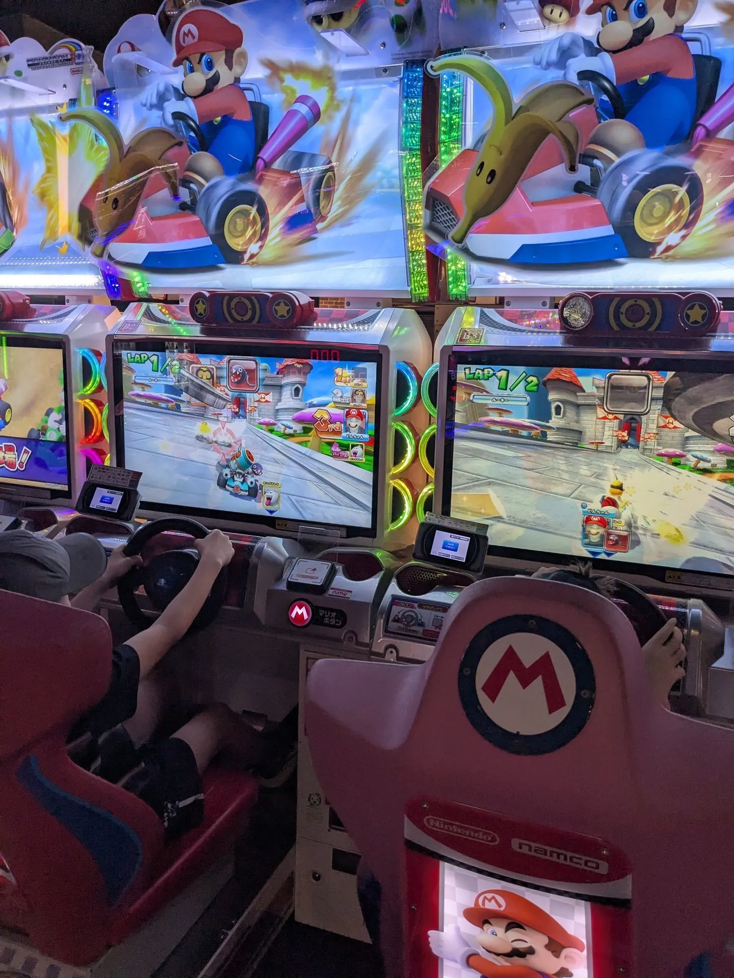 Child playing Mario Kart arcade game at GIGO Akihabara