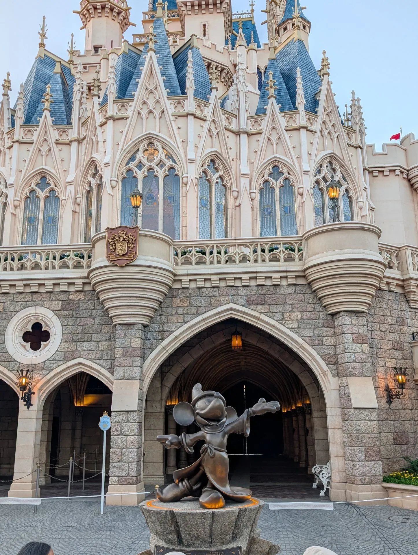 Cinderella Castle and the Mickey statue at dusk at Tokyo Disneyland