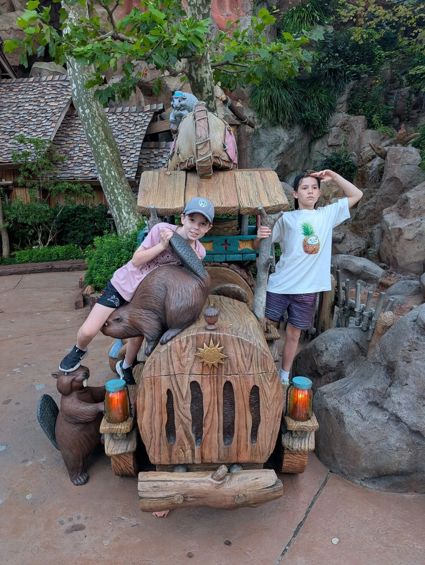 Two kids climbing on the wooden log photo prop in Critter Country at Tokyo Disneyland