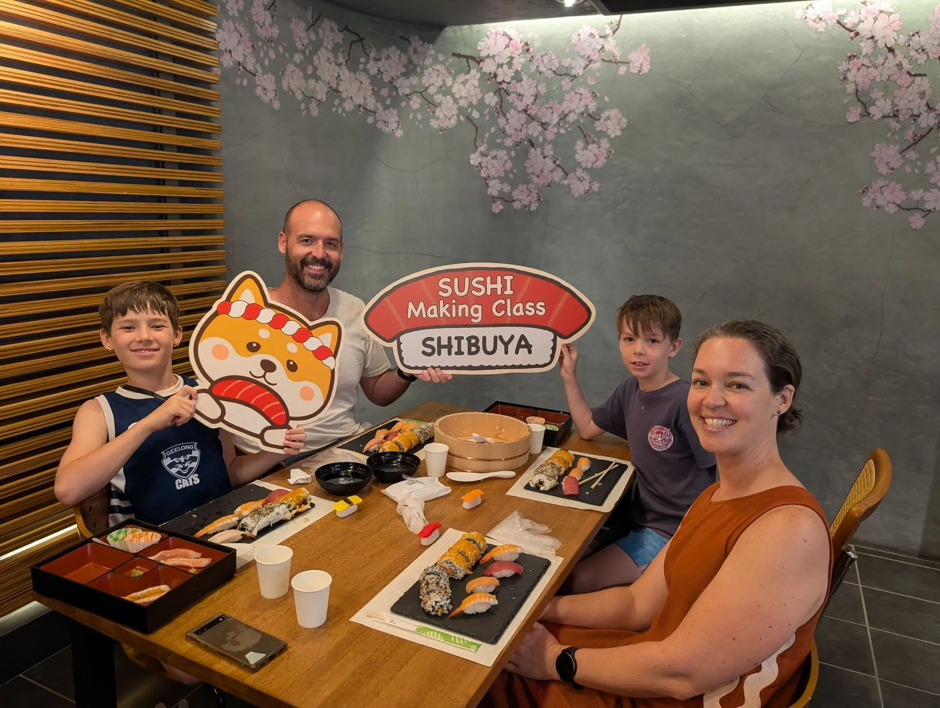 Our family at a sushi making class in Shibuya Tokyo with homemade rolls in front of us