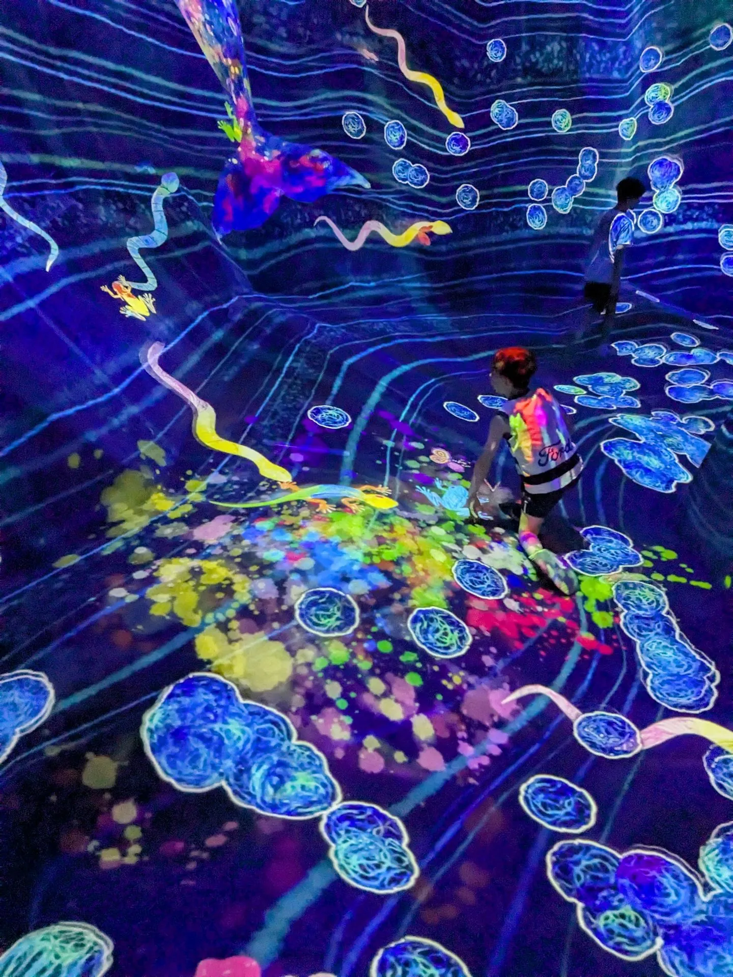 The bioluminescent ocean room at TeamLab Planets Tokyo with glowing sea creatures