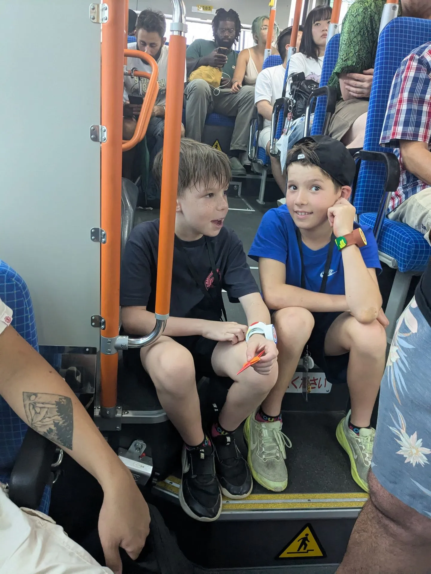 The boys sitting on a crowded Kyoto city bus