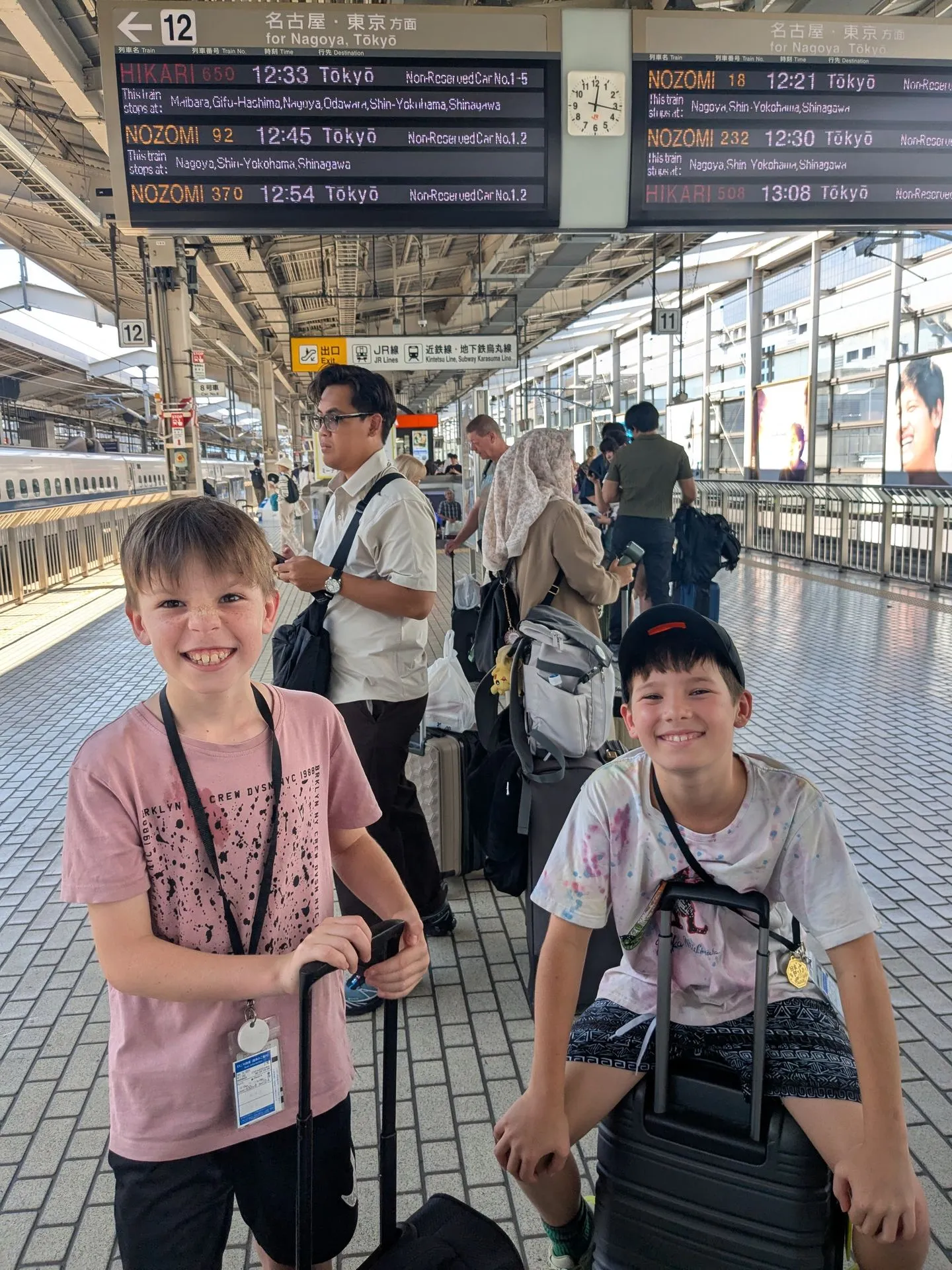 The boys on the Shinkansen platform at Kyoto Station under the departure board