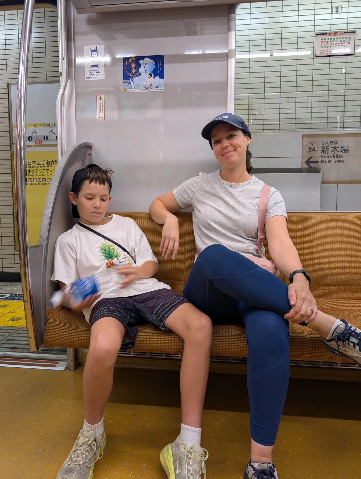 Lyndsie and one of the boys seated on the metro at Shinkiba station, Tokyo