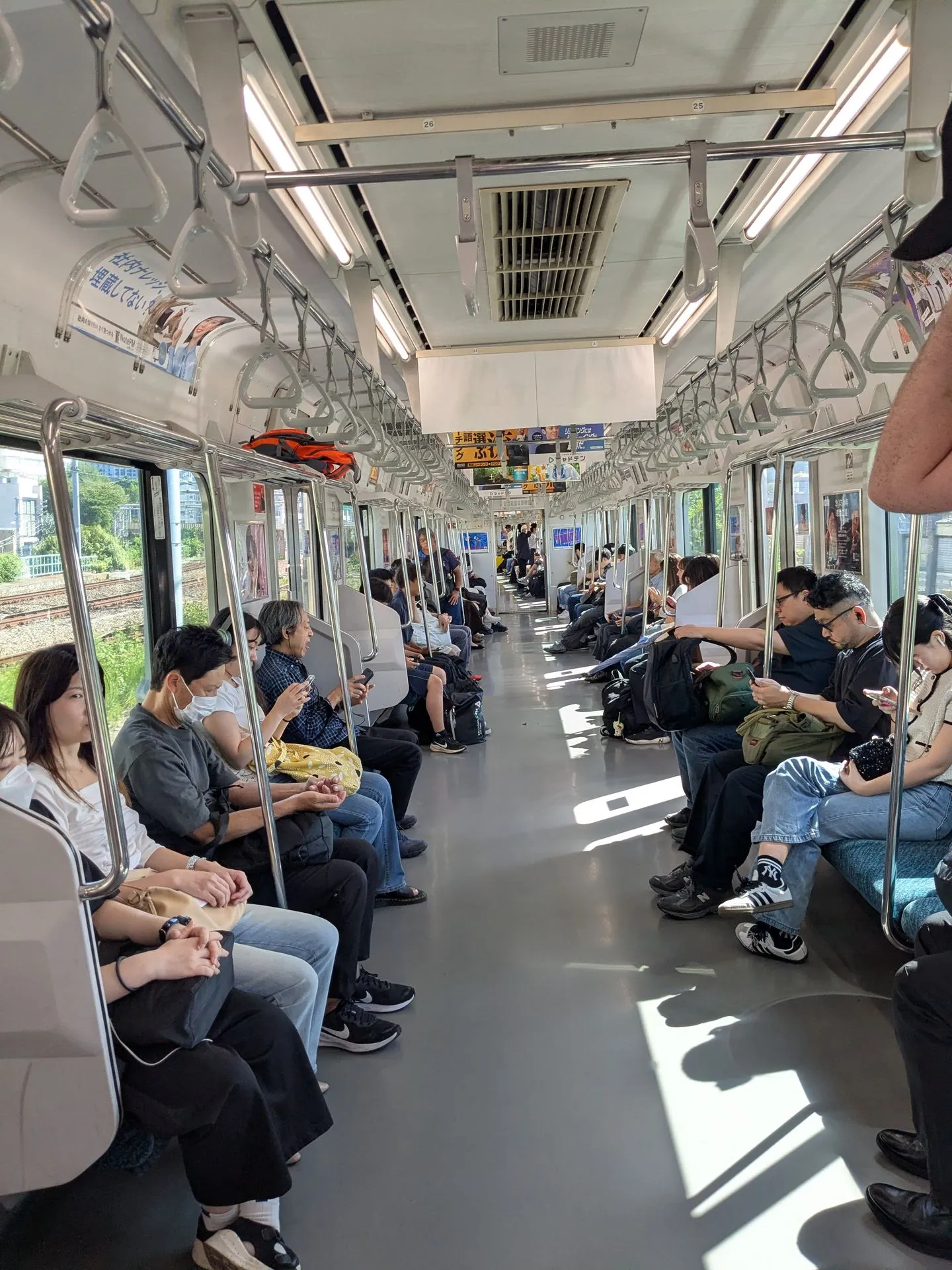 Inside a JR train carriage with passengers in Shinjuku, Tokyo