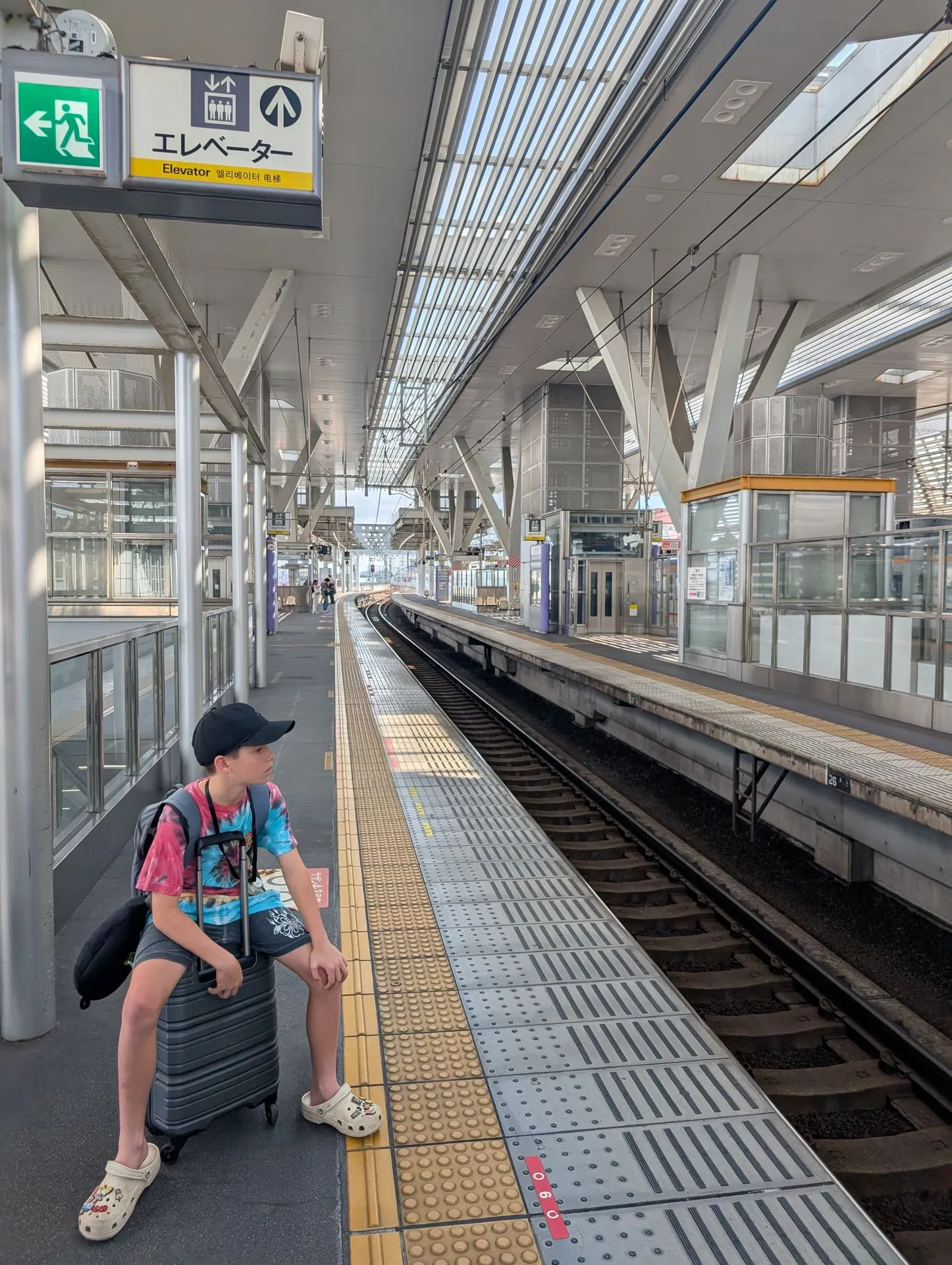 A child with luggage on a quiet rural platform on the Kii line, Wakayama